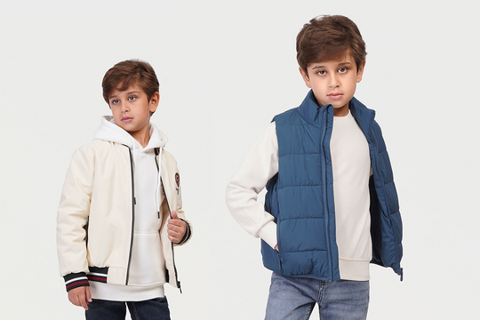 Two boys wearing winter clothing on a white background